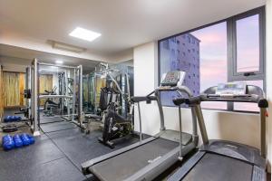 un gimnasio con cintas de correr y equipo cardiovascular en un edificio en Sky Gem Hotel Sora en Ho Chi Minh
