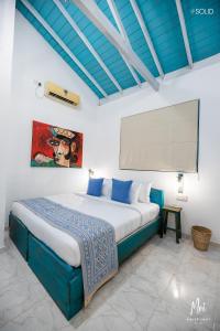 a bedroom with a large bed with blue pillows at Moi Galle Fort by DBI in Galle