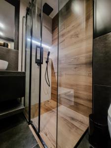 a glass shower in a bathroom with wooden floors at Heart and Soul in Tylmanowa