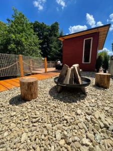 une aire de jeux avec des bûches, un banc et une maison dans l'établissement Kousek klidu, à Oldřichov v Hájích