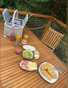 una mesa de madera con platos de comida y bebidas. en Kousek klidu en Oldřichov v Hájích