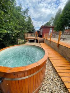 a large wooden hot tub on a wooden deck at Kousek klidu in Oldřichov v Hájích