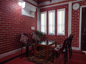 a room with a table and chairs and a brick wall at Malpe Gruham Homestay Udupi in Malpe