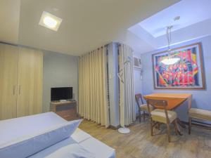 a bedroom with a bed and a table and chairs at Super OYO Capital O 907 Ceo Flats in Manila