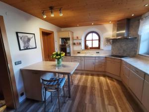 une cuisine avec une table et un vase de fleurs. dans l'établissement Ferienhaus Luise, à Samerberg