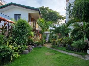 a garden in front of a house at Southpoint Hostel in Moalboal