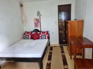 Schlafzimmer mit einem Bett und einem Holztisch in der Unterkunft Southpoint Hostel in Moalboal