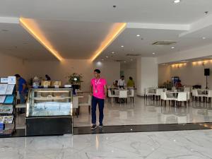 a man in a pink shirt standing in a restaurant at GOLDEN PEAK CONDO in Cebu City