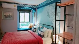 華欣的住宿－New. Beautiful One Bedroom Pool Access Condo. Only 200 metres to the beach.，一间卧室设有红色的床和蓝色的墙壁