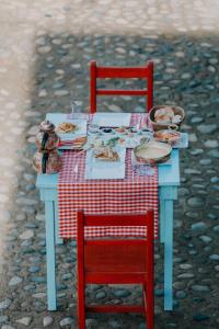 Hobbitköy giresun في غيرسون: طاولة بها أطباق من الطعام وكرسيين حمراء