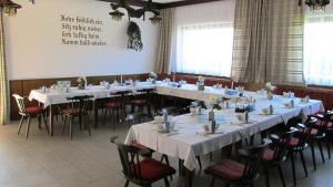 ein großes Zimmer mit Tischen und Stühlen mit weißen Tischdecken in der Unterkunft Gasthof Kaiser in Sankt Veit an der Glan