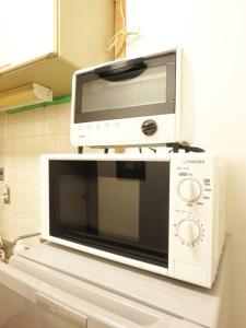 a microwave sitting on top of a refrigerator at Dotonbori Mansion 401 in Osaka