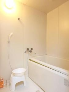 a white bathroom with a toilet and a bath tub at Dotonbori Mansion 401 in Osaka