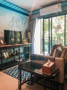 un soggiorno con divano e tavolo di New. Beautiful One Bedroom Pool Access Condo. Only 200 metres to the beach. a Hua Hin