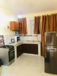 een keuken met bruine kasten en een fornuis met oven bij Mtwapa Apartment in Mombasa