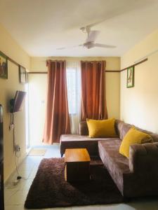 a living room with a brown couch with yellow pillows at Mtwapa Apartment in Mombasa