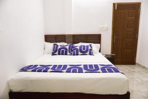 ein Schlafzimmer mit einem Bett mit lila und weißen Kissen in der Unterkunft Je Sant O Casa Homestay in Kochi