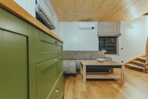 a kitchen and living room with a couch and a table at Želvė Village & SPA in Želviai