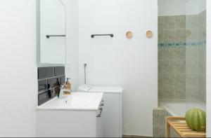 y baño blanco con lavabo y ducha. en LE LUCIEN Eco-Appart'Hôtel - Angouleme - Centre - Wifi - Parking privé - Classé 4 étoiles, en Angulema
