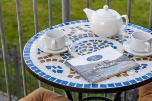 een tafel met twee kopjes en een theepot erop bij Tollyrose Loft apartment in Newcastle +12 foto's