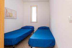 トッレ・モッツァにあるAppartamento climatizzato a 50 m dalla spiaggia con patio esternoの窓付きの小さな部屋のベッド2台