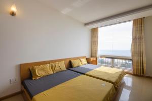 1 dormitorio con cama y ventana grande en Son Thinh Apartment, en Vung Tau