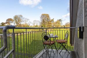 a table and chairs on a balcony with a view of a field at Tollyrose Loft apartment in Newcastle