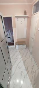 een badkamer met een marmeren vloer en een spiegel bij Menrat in Novi Sad