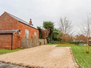 Mill Lane Cottage في تشيستر: منزل من الطوب وامامه طريق ترابي