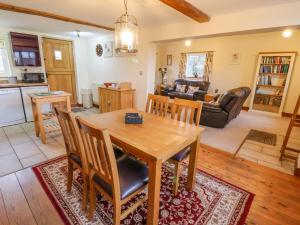 Mill Lane Cottage في تشيستر: مطبخ وغرفة معيشة مع طاولة وكراسي خشبية