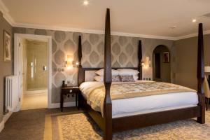 a bedroom with a large bed and a walk in shower at Oakley Hall Hotel in Basingstoke