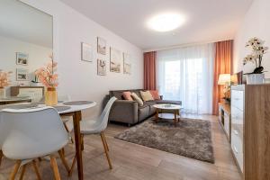 uma sala de estar com uma mesa e um sofá em OMI Apartments em Colberga