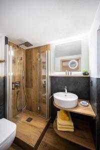 een badkamer met een douche, een wastafel en een toilet bij Schittlerhof in Fischen