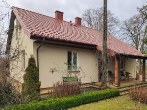 a small white house with a red roof at Dom Nad Narwią Łubienica 15 in Łubienica