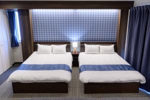 a hotel room with two beds and a window at Sugamo Winco Residence in Tokyo