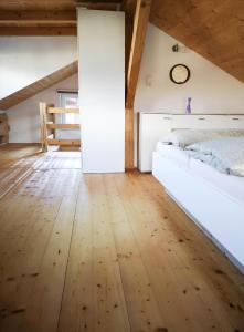 a bedroom with a white bed and a wooden floor at Haus Matzenblick in Reith im Alpbachtal