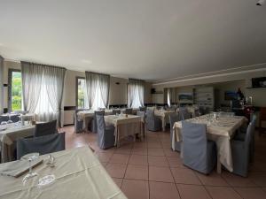 a dining room with tables and chairs with white tablecloths at Albergo del mera-ristorante da Lui in Sorico