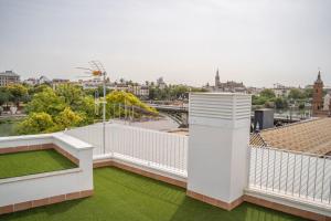 einen weißen Balkon mit grünem Gras auf einem Gebäude in der Unterkunft Optimus Apartments Corazón de Triana in Sevilla
