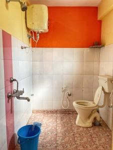 a bathroom with a toilet and a bucket in it at Sandev Homestay in Madikeri