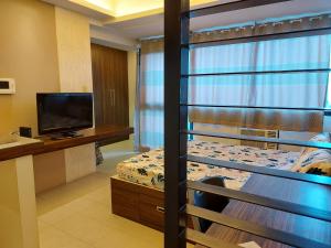 a bedroom with a bunk bed and a television at Romantic 1 Bedroom with Pool in Manila