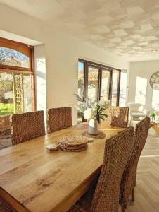 a dining room with a wooden table and chairs at Seaside Cottage, 8min walk to beach. Dog friendly. in Norwich