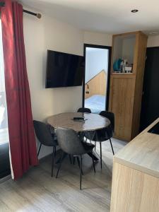 ブール・サン・モーリスにあるAppartement F2 aux Glièresのテーブルと椅子、テレビが備わる客室です。