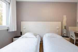Ένα ή περισσότερα κρεβάτια σε δωμάτιο στο Hôtel Vulcain