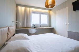 Ένα ή περισσότερα κρεβάτια σε δωμάτιο στο Hôtel Vulcain