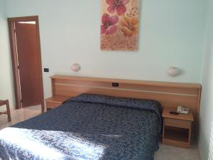 a bedroom with a bed and a painting on the wall at Hotel Corallo in Finale Ligure