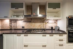 a kitchen with white cabinets and a stove top oven at Delightful Flat with Bosphorus View in Kuzguncuk in Istanbul