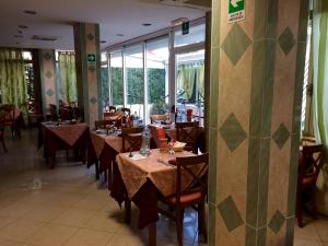 un comedor con mesas y sillas en un restaurante en Hotel Corallo en Finale Ligure
