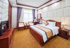 una mujer parada en una habitación de hotel con una cama en Khách Sạn A1, en Lạng Sơn