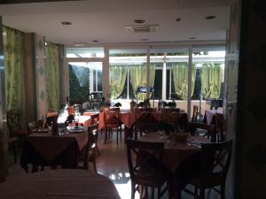 a dining room with tables and chairs and windows at Hotel Corallo in Finale Ligure +19 photos