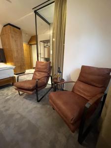 Zimmer mit zwei braunen Stühlen und einem Spiegel in der Unterkunft Boutique hotel & spa DOMA u nás - entry AquaCity free in Poprad